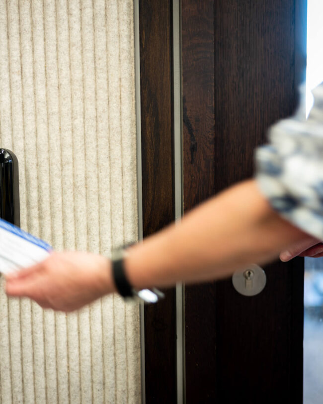 Room scanner in use by a female entering with her ID card