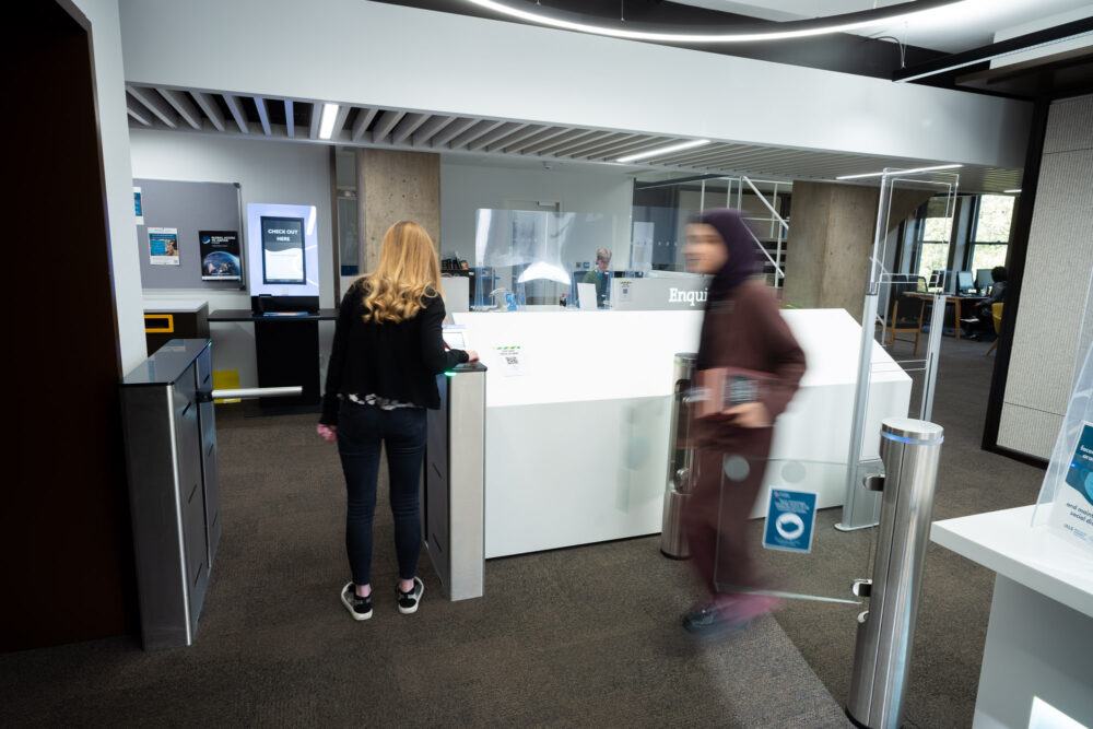 Person scanning their pass on access control pad