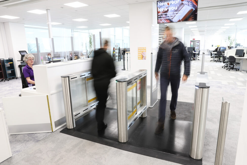 Two people walking through alarmed security gates