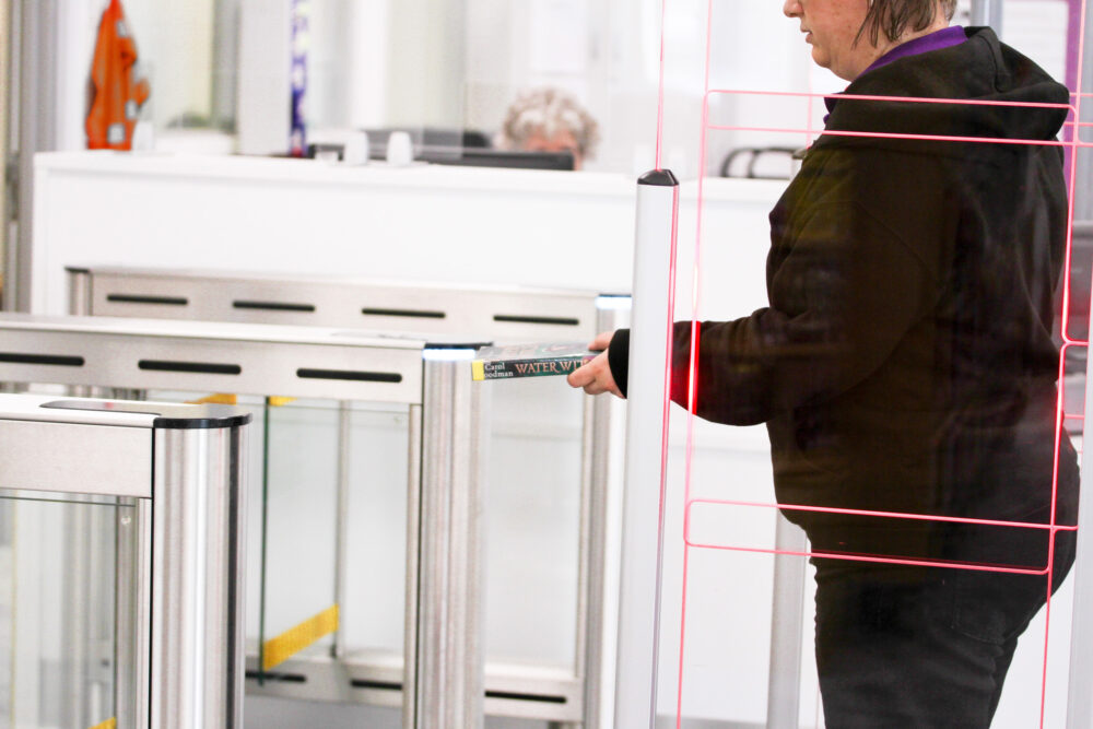 Person walking through security gate with video