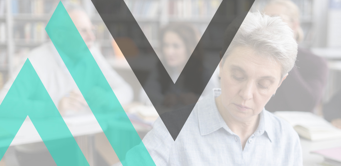 Woman sat in the library with people behind her with open books on the table