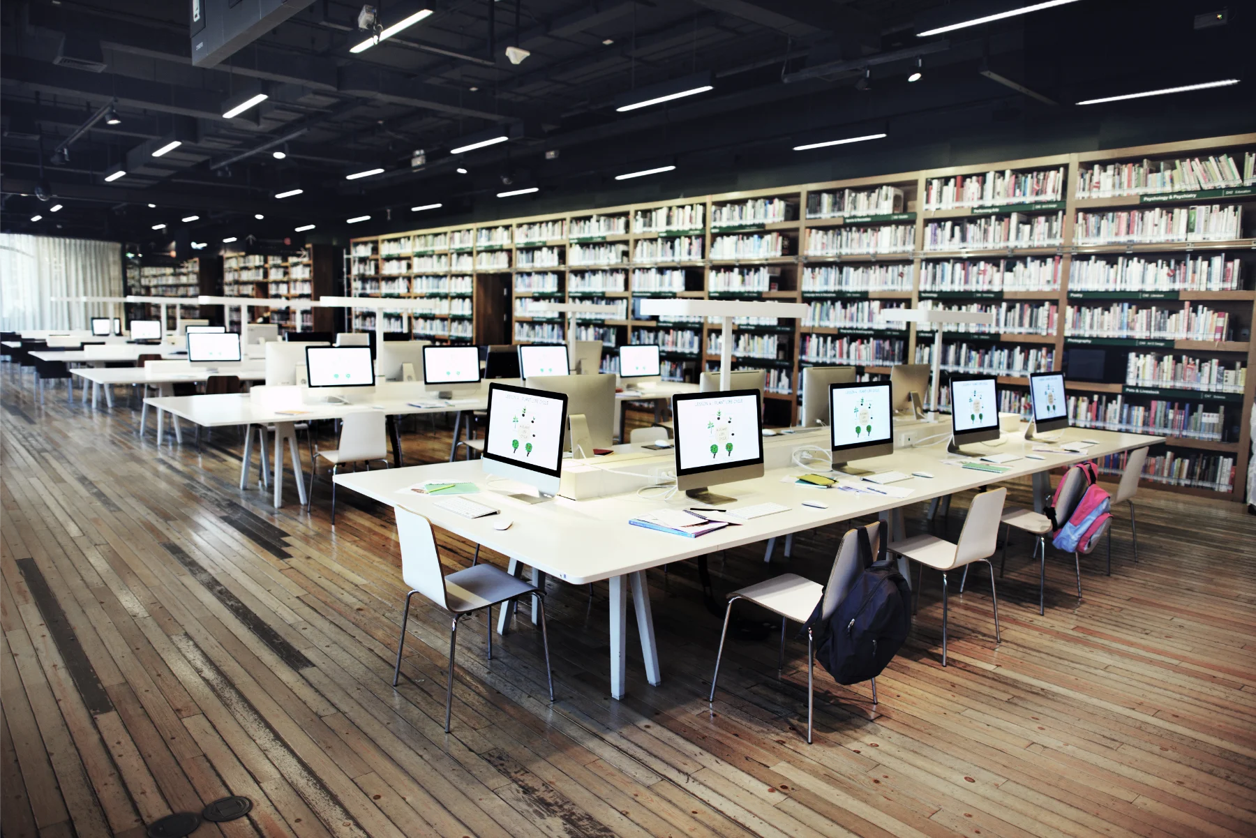 Rows of desks with computers in a University library Rows of desks with computers in a University library